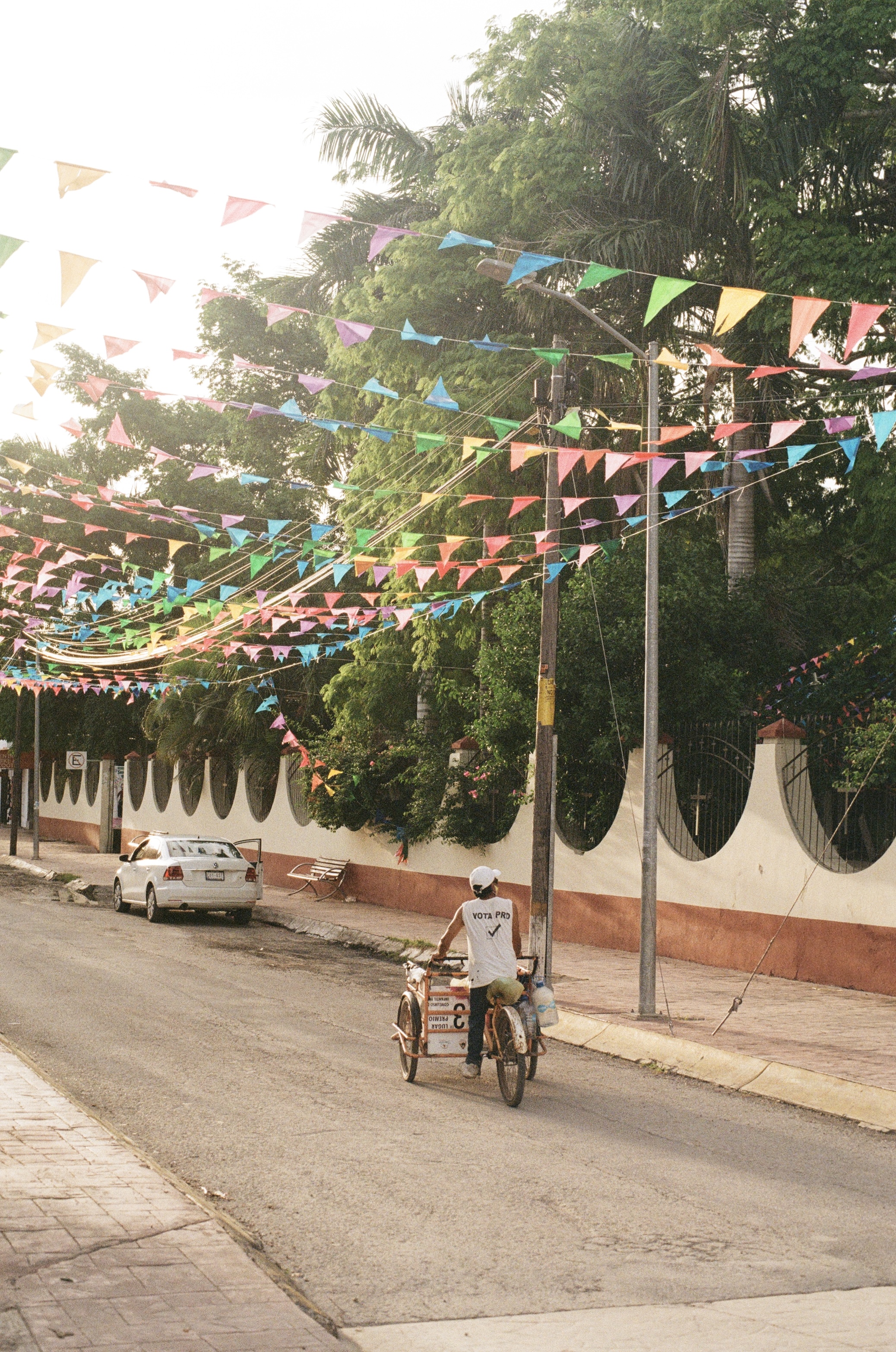 Man riding a bicycle under colourful bunting